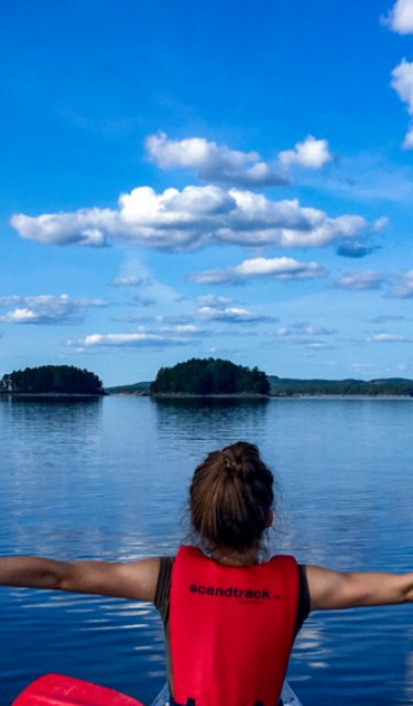 Person im Kanu auf ruhigem See in der Seenlandschaft der Nordmarken in Värmland, Schweden, während einer mehrtägigen Kanutour.